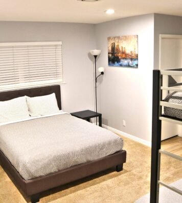 Image shows a contemporary bedroom with a large bed and bunk beds for guests in Las Vegas.